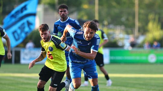 Der Metternicher Hendrik Hillen (links) im Laufduell um den Ball mit dem Gülser 
Kerim Arslan (in Blau) - am Ende hatte die Germ