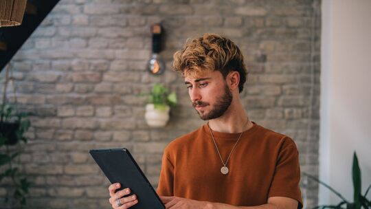 Ein Mann hält ein Tablet in den Händen Ein Mann hält ein Tablet in den Händen
