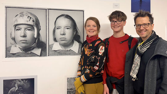 Tobias Titz (rechts), hier mit Sohn Theo und Ehefrau Kiera, vor den ausgestellten Portraits der Künstlerin Shoshanna Brott, mit