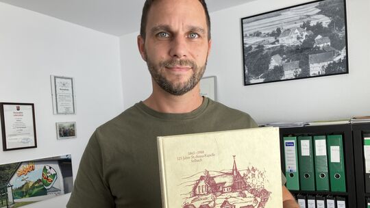 Ortsbürgermeister Matthias Grohs mit dem 1988 von Bruno Osinski und Lothar Radermacher verfassten "Selbacher Heimatbuch". Der ei