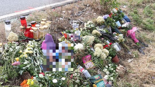 Trauernde haben Blumen, Kerzen und Geschenke für die Opfer an der Straße hinterlassen.