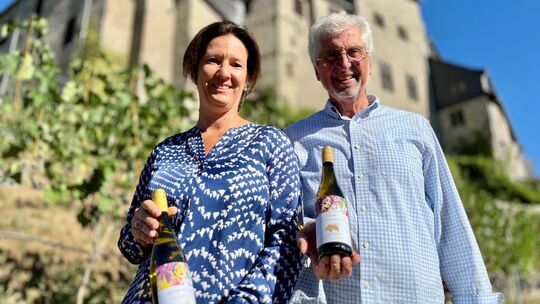 Corinna John (50) und Bernhard Unkelbach (74) präsentieren vor dem Weinberg ihres Vereins "Limburger Schlosswingert" die ersten