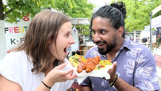 Diese beiden Besucher ließen es sich trotz der Hitze auf dem Street-Food-Festival auf dem Neuwieder Marktplatz schmecken.