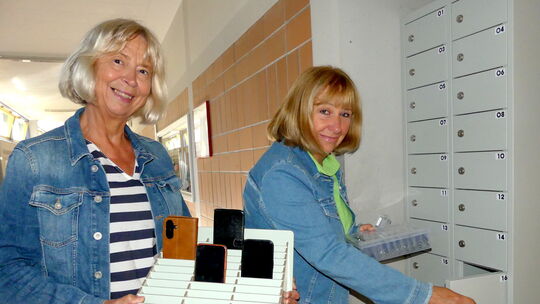 Schulleiterin Karin Hofmann (rechts) und ihre Stellvertreterin Jutta Lißmann präsentieren die neuen Handy-Garagen und Handy-Park