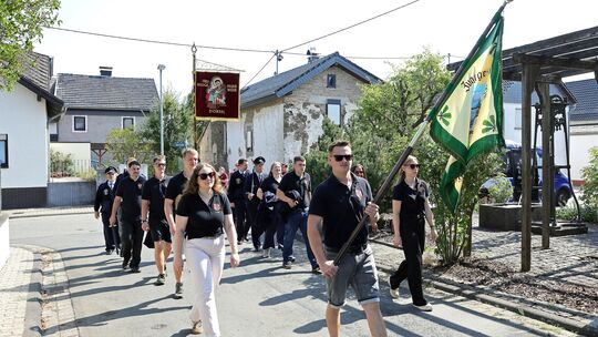 Von der Kirche zum Festzelt: Junggesellen, Freiwillige Feuerwehr, die Bergmusikanten Hoffeld und Einwohner sind unterwegs.