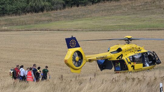 Einsatzkräfte bereiten den Transport des verletzten Motorradfahrers zum Rettungshubschrauber vor.