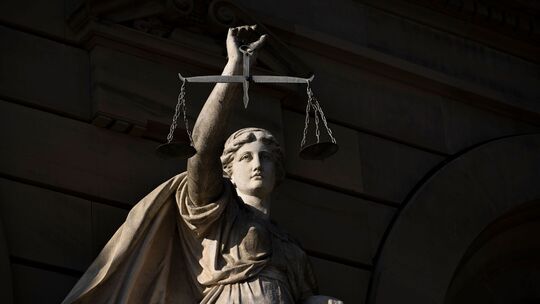 Vor einem Justizgebäude steht die Statue einer Justitia Vor einem Justizgebäude steht die Statue einer Justitia