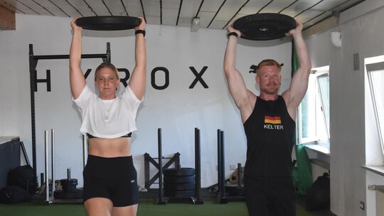 Eine der Übungen der Sportart Deadly-Dozen: Beim „Overhead Carry“ tragen die Sportler ein Gewicht über den Kopf und müssen damit Eine der Übungen der Sportart Deadly-Dozen: Beim „Overhead Carry“ tragen die Sportler ein Gewicht über den Kopf und müssen damit
