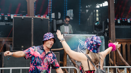 Die Besucherinnen und Besucher feiern in bunten Outfits bei gutem Wetter beim Festival Castle Beats in Brodenbach.