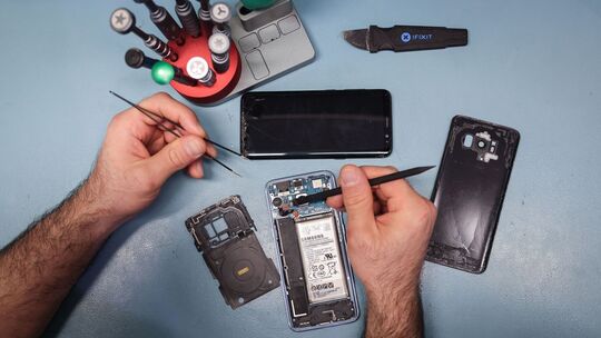 Techniker arbeitet an einem Smartphone mit defektem Display Techniker arbeitet an einem Smartphone mit defektem Display