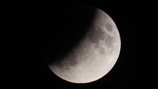 Der Mond ist während einer partiellen Mondfinsternis etwa zur Hälfte durch den Schatten der Erde verdeckt.