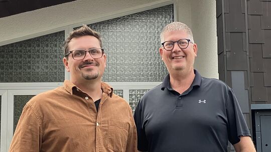 René Schulte (von links) und Daniel Müller von der Gemeindeleitung der Kirche im Westerwald stehen vor dem alten Standort in Wöl