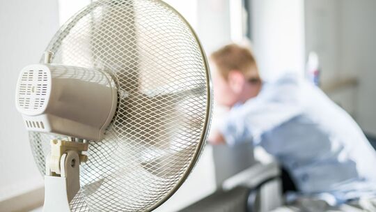 Ein Ventilator steht in einem Büro Ein Ventilator steht in einem Büro