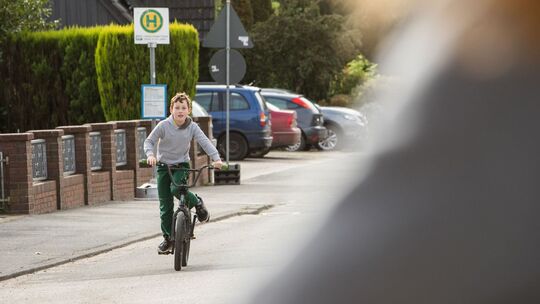 Junge fährt mit dem Fahhrad auf einer Straße