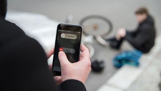 Eine Frau tätigt einen Notruf nach einem Fahrradunfall Eine Frau tätigt einen Notruf nach einem Fahrradunfall