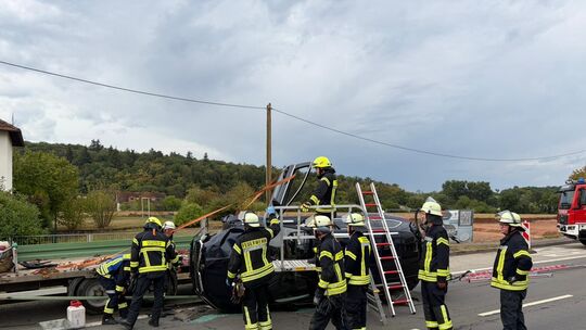 Feuerwehrkräfte sichern den auf der Seite liegenden Skoda nach einem Unfall in der Rüdesheimer Nahestraße. Ersthelfer hatten zuv Feuerwehrkräfte sichern den auf der Seite liegenden Skoda nach einem Unfall in der Rüdesheimer Nahestraße. Ersthelfer hatten zuv