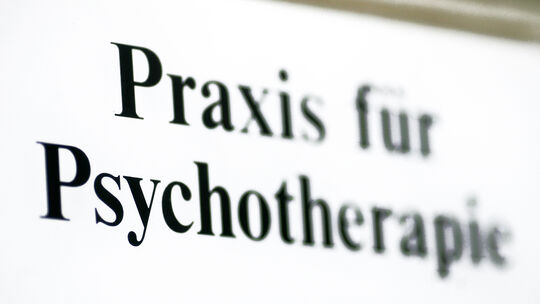Ein Schild weist auf eine Praxis für Psychotherapie hin.
