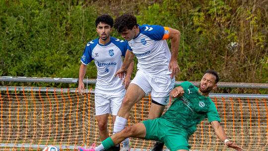 Der Einsatz stimmt: Der Baumholderer Ahmad Tajik (grünes Trikot) grätscht dem Zeiskamer Kapitän Aaron Gracia den Ball vom Fuß. I
