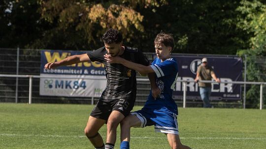 Zein Jalkama (schwarzes Trikot) und die SG Weinsheim bleiben auswärts ungeschlagen, spielten in Nanzdietschweiler 1:1.