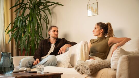 Ein Mann und eine Frau sitzen auf einem Sofa