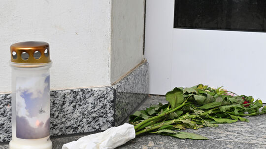 Vor dem Haus in der Ramersbacher Straße in Ahrweiler sind nach der Familientragödie Blumen abgelegt und eine Kerze aufgestellt w