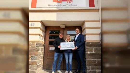 Johannes Tittel (von rechts) vom Bistum Trier überreicht einen dicken Scheck an Ulrike Michelt und Patrick Book vom HoT.