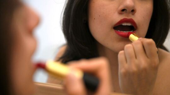 Lippenstift auftragen vor dem Spiegel