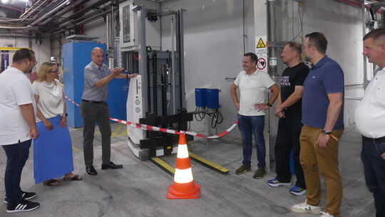 Die Funktion des neu angeschaften Roboter-Gabalstaplers erläutert der technische Leiter Dr. Joachim Wolf (3. von links), was auc Die Funktion des neu angeschaften Roboter-Gabalstaplers erläutert der technische Leiter Dr. Joachim Wolf (3. von links), was auc