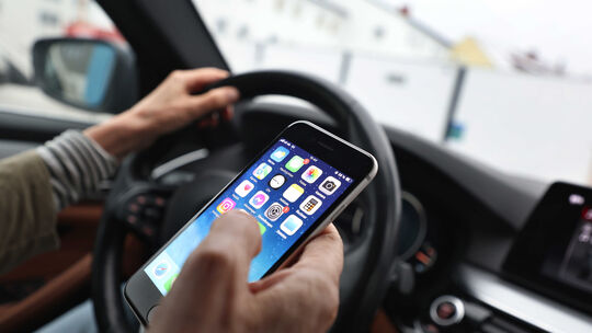 Gefährliche Ablenkung durchs Smartphone: Ein Blick aufs Handy kann sekundenlange Unaufmerksamkeit bedeuten. Das Unfallrisiko ste