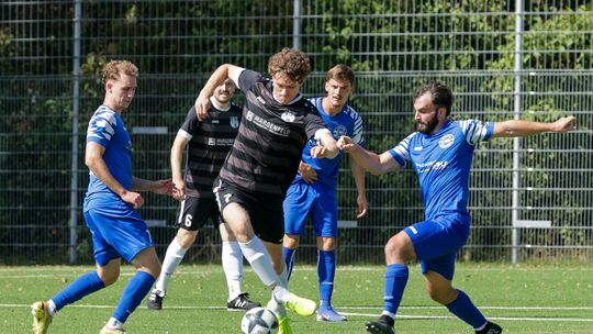 Marvin Kerber vom FC Horchheim (am Ball) versucht sich gegen seine Gegenspieler vom TuS Niederberg (blaue Trikots) durchzusetzen