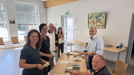 Andrang am Wahltag. Ortsbürgermeister Günter Klasson (links stehend), Gerd Müller (vorn) und Heike Beenen (leicht verdeckt) gebe