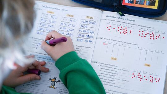 Schüler einer vierten Klasse arbeitet an Matheaufgaben Schüler einer vierten Klasse arbeitet an Matheaufgaben