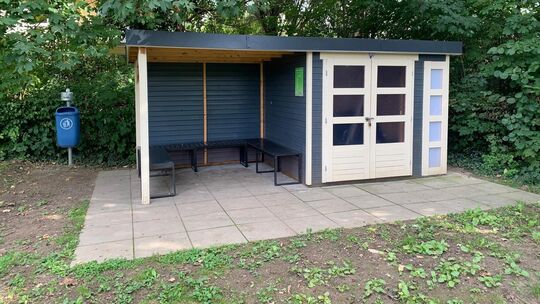 Gartenhaus im Generationengarten Schläfer mit überdachtem Freisitz, in dem der Verein die Geräte für die Gartenpflege abgestellt