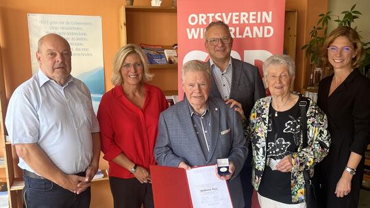 Waldemar Roos hält die Urkunde und die verdiente Willy-Brandt-Medaille in den Händen. Seine Frau Edith steht auch bei diesem bes