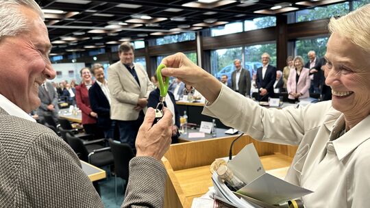 Kreisbeigeordnete Gabriele Wieland stattet den neuen Landrat Klaus Lütkefedder mit den wichtigsten Utensilien für seinen Amtsant