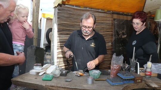 Goldschmiedemeister Rolf Schneider (Mitte) zeigt beim Stein- und Burgfest die Herstellung von Schmuck in Sandguss und mithilfe e