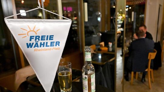 Eine Fahne mit der Aufschrift „Freie Wähler Rheinland-Pfalz“ steht auf einem Tisch. Bei der Landtagswahl im März scheiterte die Eine Fahne mit der Aufschrift „Freie Wähler Rheinland-Pfalz“ steht auf einem Tisch. Bei der Landtagswahl im März scheiterte die