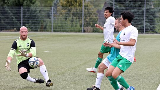 Niederroßbachs Torwart Simon Schell (links), der hier vor Niederahrs Thanh Truong und Jair Francisco Gamarra Martinez am Ball is