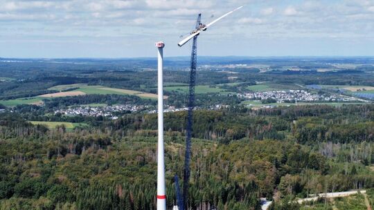 Das erste Rotorblatt schwebt in luftigen Höhen in Richtung Nabe und wird an der Windenergieanlage 06 im Windpark Haiderbachhöhe