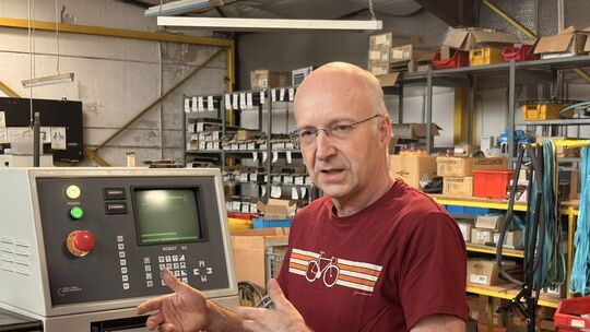 Jan Schauff erklärt die Funktionsweise seiner Maschinen. Er ist Inhaber der Fahrradfabrik Schauf in Remagen.
