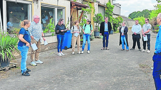 Mitglieder des Bauausschusses, der Verwaltung und des Magistrats stehen auf dem Hof der ehemaligen Staudengärtnerei im Schirling