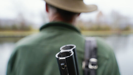 Ein Jäger steht mit seinem Gewehr in seinem Jagdrevier. Symbolfoto