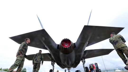 Soldaten der Bundeswehr betrachten ein Modell eines Kampfflugzeugs vom Typ Lockheed Martin F-35 Lightning II der italienischen L