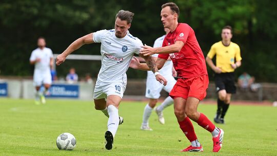 Der Koblenzer Vladislav Helmert (rotes Trikot) jagt dem Ball und dem Neuwieder Fabian Weber (links) hinterher.