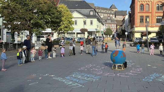 Rund 30 Kita-Kinder aus Diez versammelten sich um eine Miniaturweltkugel, um gemeinsam zu singen.