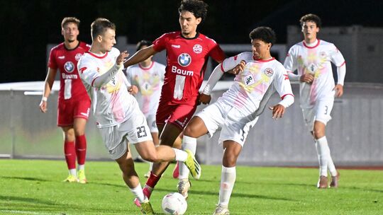 Der Ahrweiler BC um Beykan Ali Sengül (in Rot) hat den ersten Saisonsieg gefeiert und Rot-Weiss Koblenz um Phil Thieltges (und Z Der Ahrweiler BC um Beykan Ali Sengül (in Rot) hat den ersten Saisonsieg gefeiert und Rot-Weiss Koblenz um Phil Thieltges (und Z