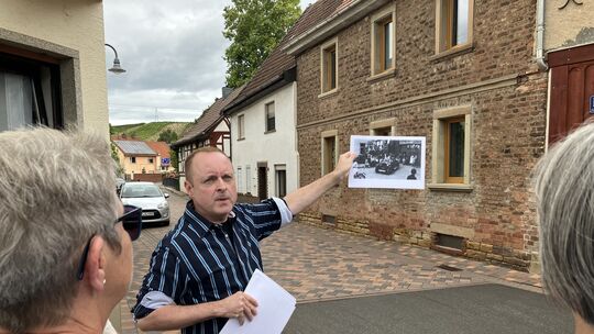 Marcus Becker hält an der Kreuzung Hundsgasse/Kirchgasse/Backesgasse ein Foto aus dem Jahr 1930 hoch. Der Sportverein feierte Ju