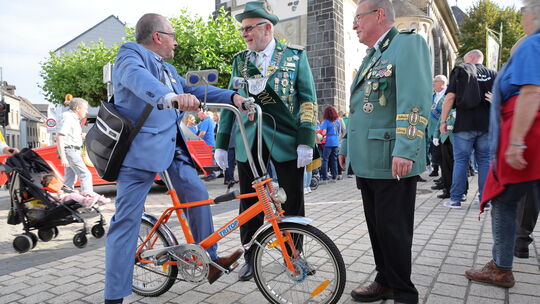 Weißenthurms Stadtbürgermeister Joachim Juchem (FWG) begrüßt auf dem Bonanza-Fahrrad sitzend die Schützen aus Weißenthurm.