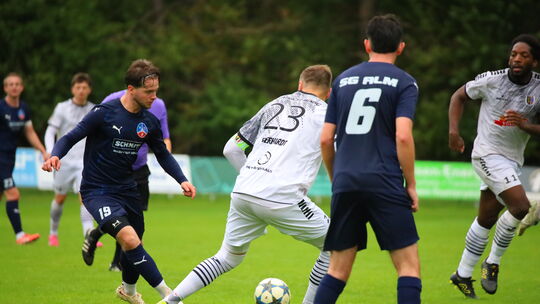 Die beiden Torschützen beim 1:1 zwischen der SG Liebshausen/Mörschbach/Argenthal (in Blau) und dem SV Mendig auf einem Bild: Leo
