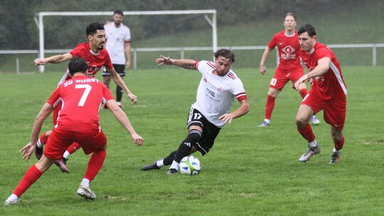 Im Dauerregen von Neuhäusel geriet der FV Rübenach (am Ball Antonio Fejza) früh ins Schlingern und musste sich am Ende klar der